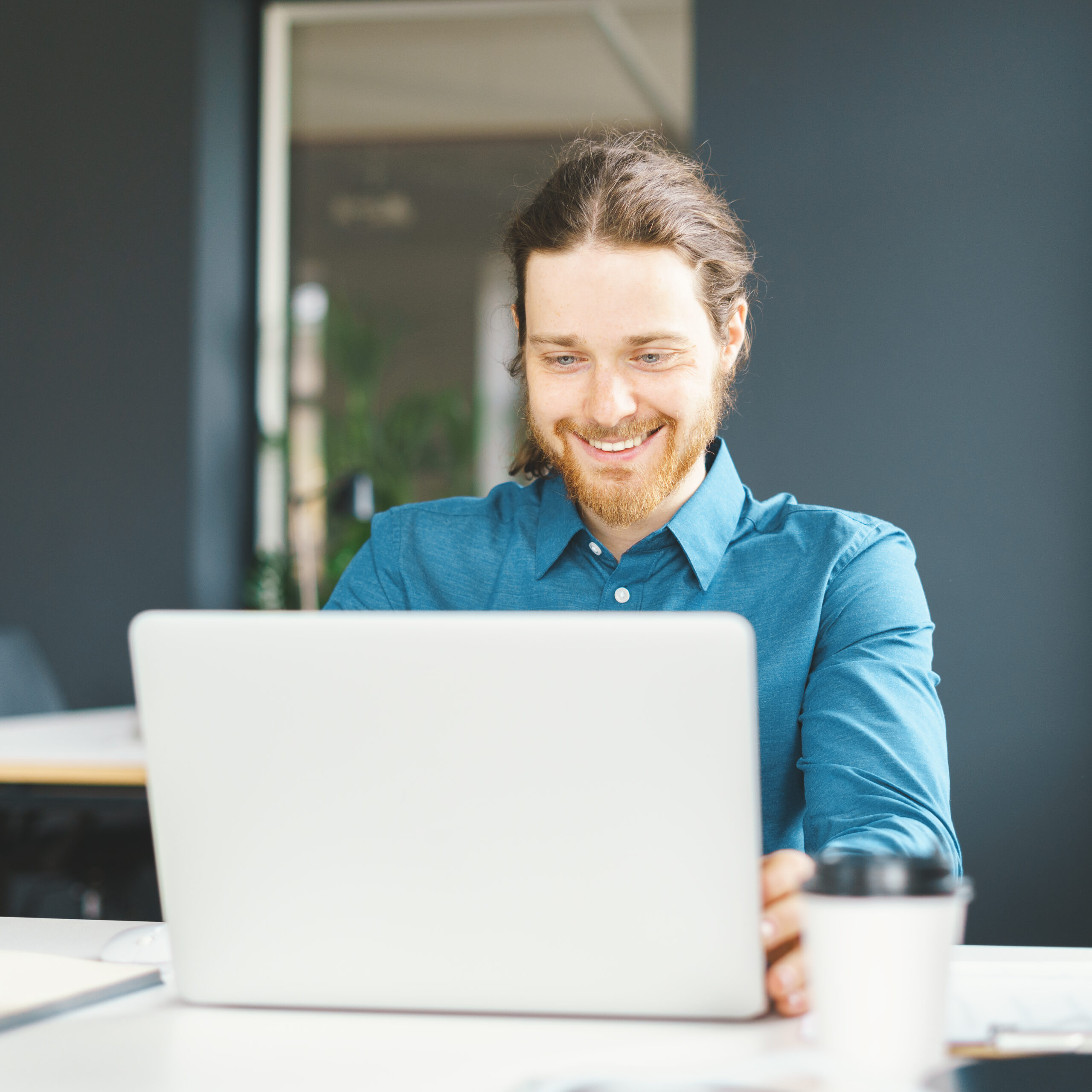 Développeur web freelance souriant travaillant sur un projet innovant éligible au CII avec symbole de fusée représentant l'innovation